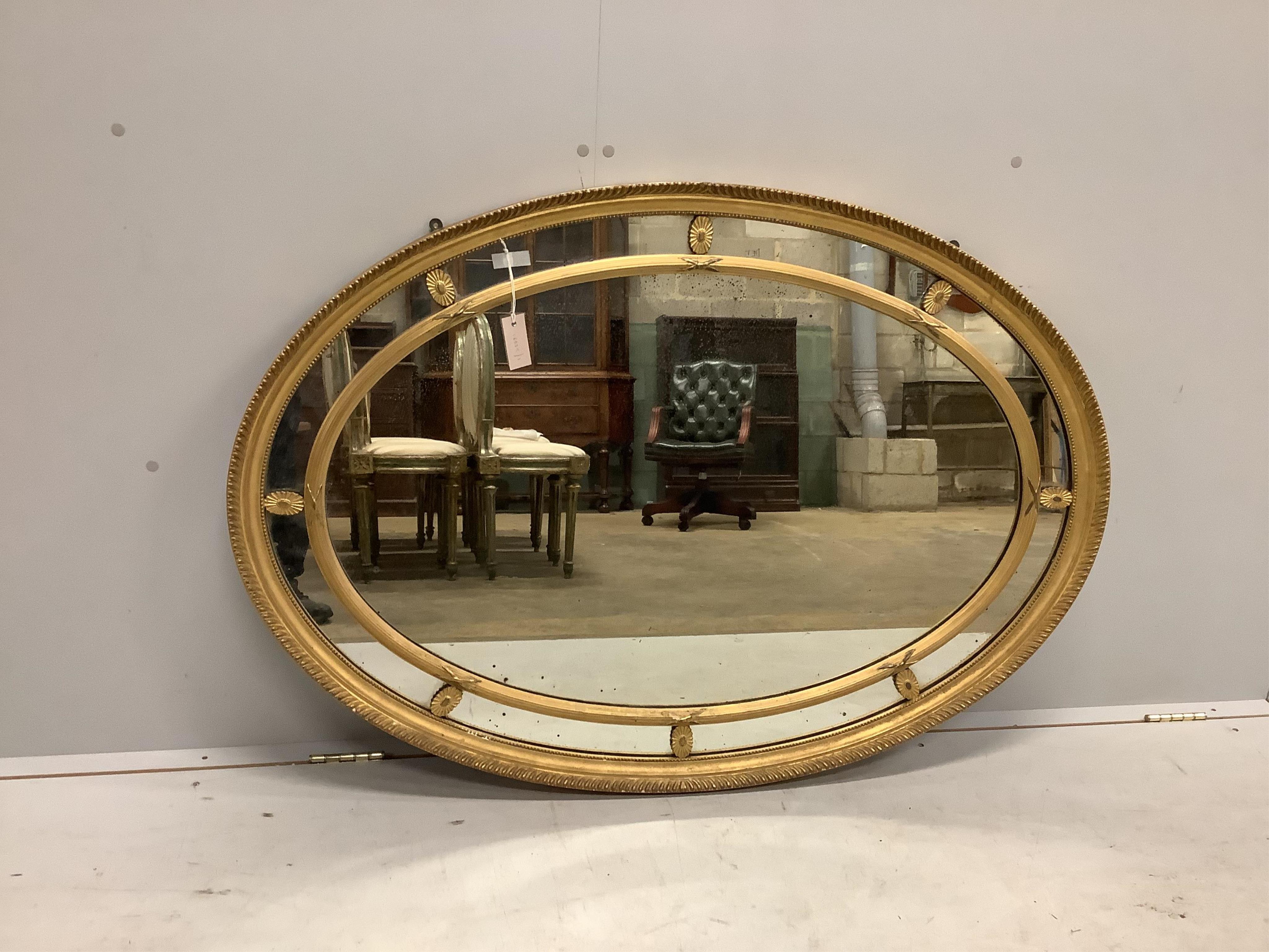 A George III style oval giltwood and composition marginal plate wall mirror, width 124cm, height 86cm. Condition - fair to good, plate spotted